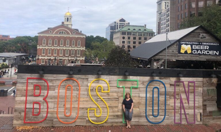 woman standing in front of the BOSTON sign